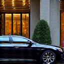 Luxury chauffeur-driven car waiting outside a grand hotel