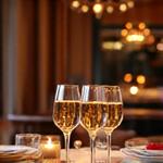 A sophisticated couple raising champagne flutes at a romantic chef's table in Rome